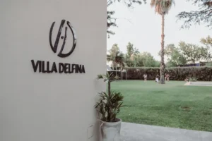 Logo de Villa Delfina con el parque de fondo